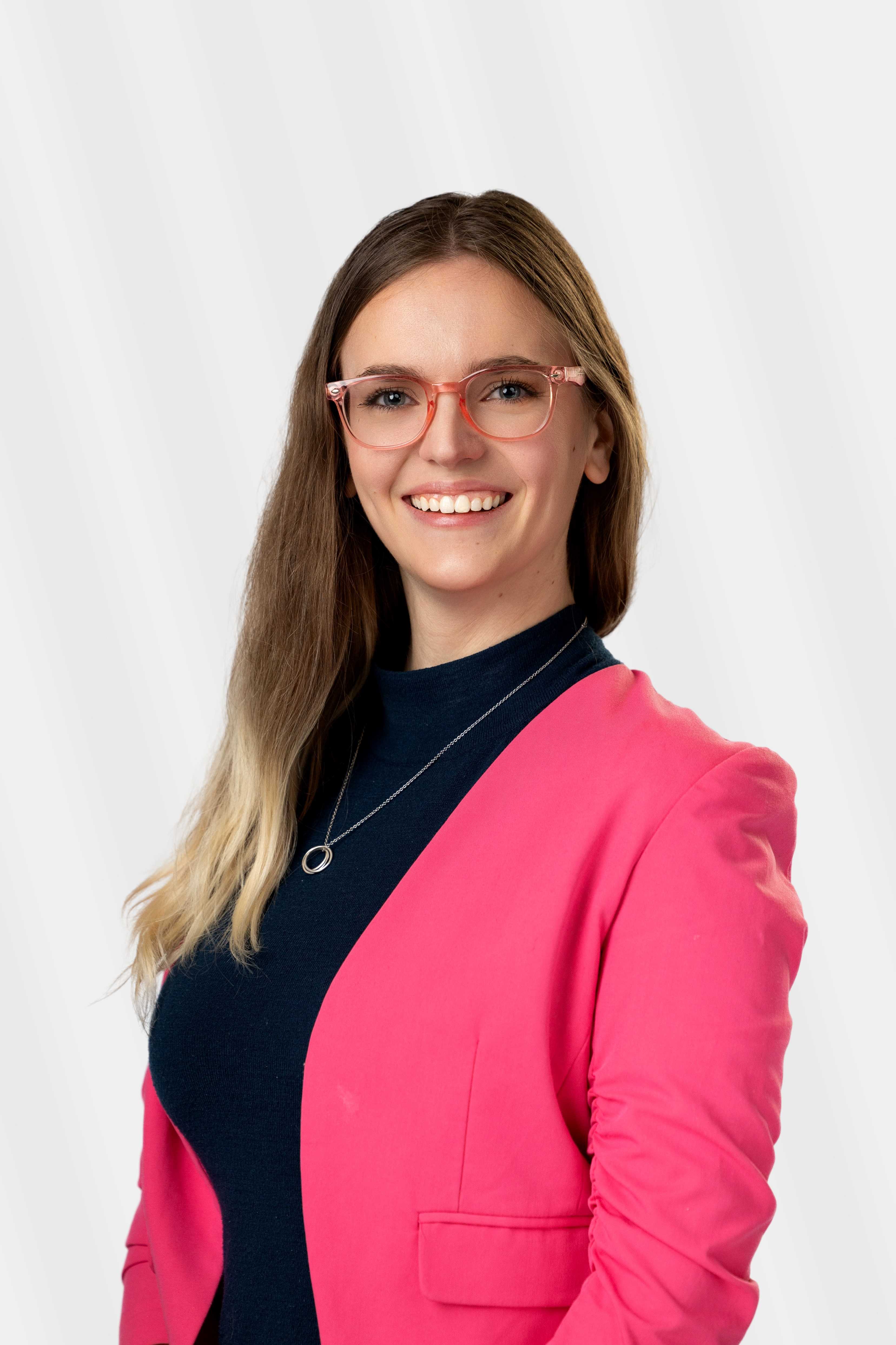 Abigal Free smiling in a headshot with a pink blazer