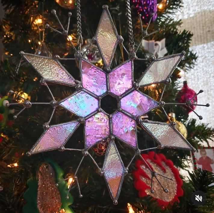 Irridescent star in front of a Christmas tree