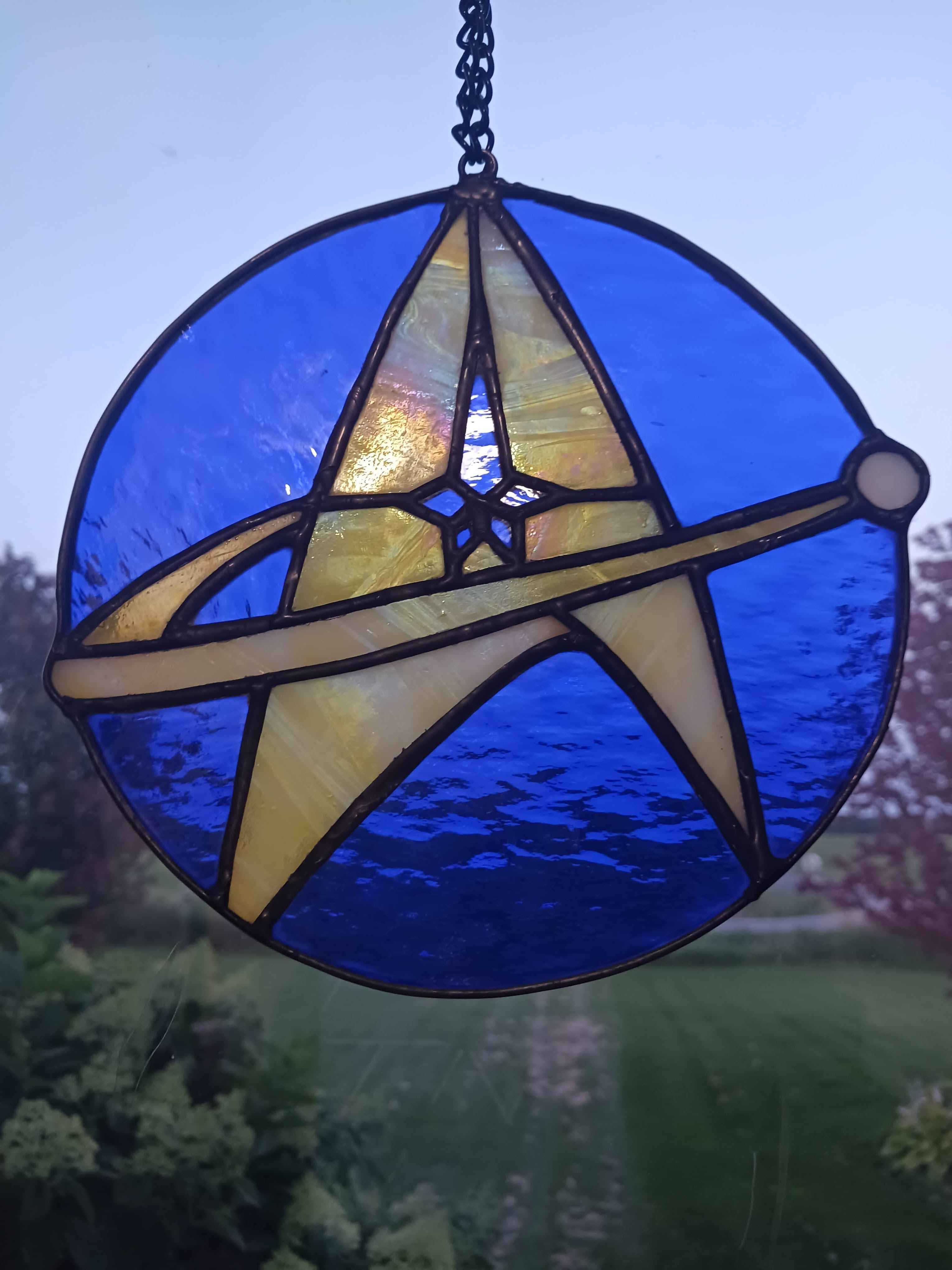 A circular star trek emblem stained glass piece